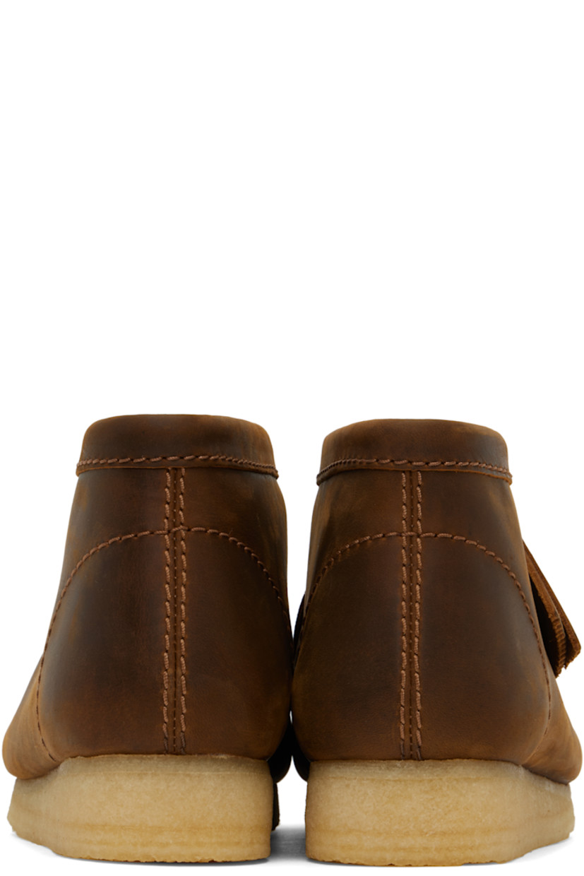 Ankle-high waxed leather desert boots in brown.

· Square moc toe
· Logo tags at lace-up closure
· Suede lining
· FSC-certified crepe rubber sole

Supplier color: Beeswax