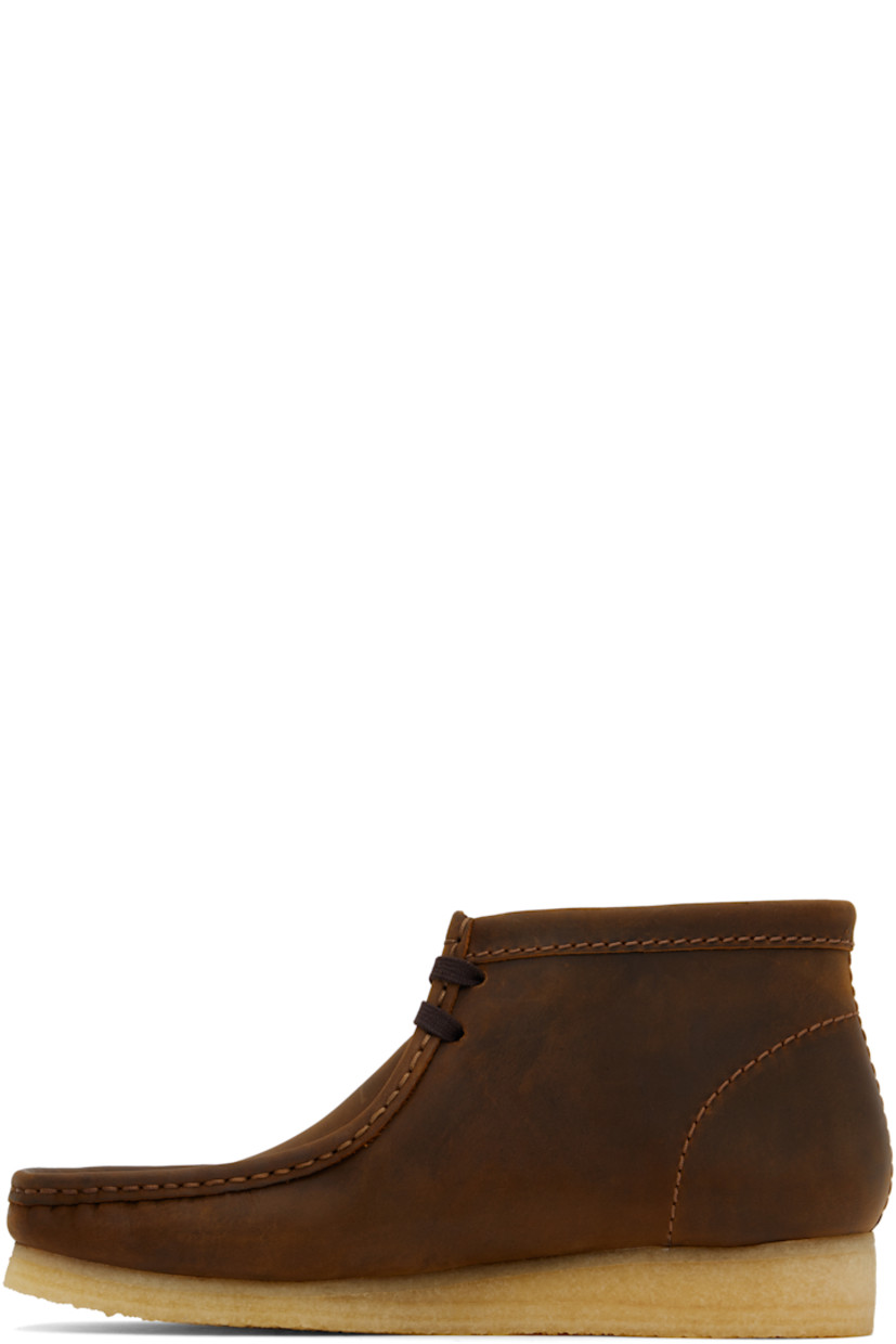 Ankle-high waxed leather desert boots in brown.

· Square moc toe
· Logo tags at lace-up closure
· Suede lining
· FSC-certified crepe rubber sole

Supplier color: Beeswax