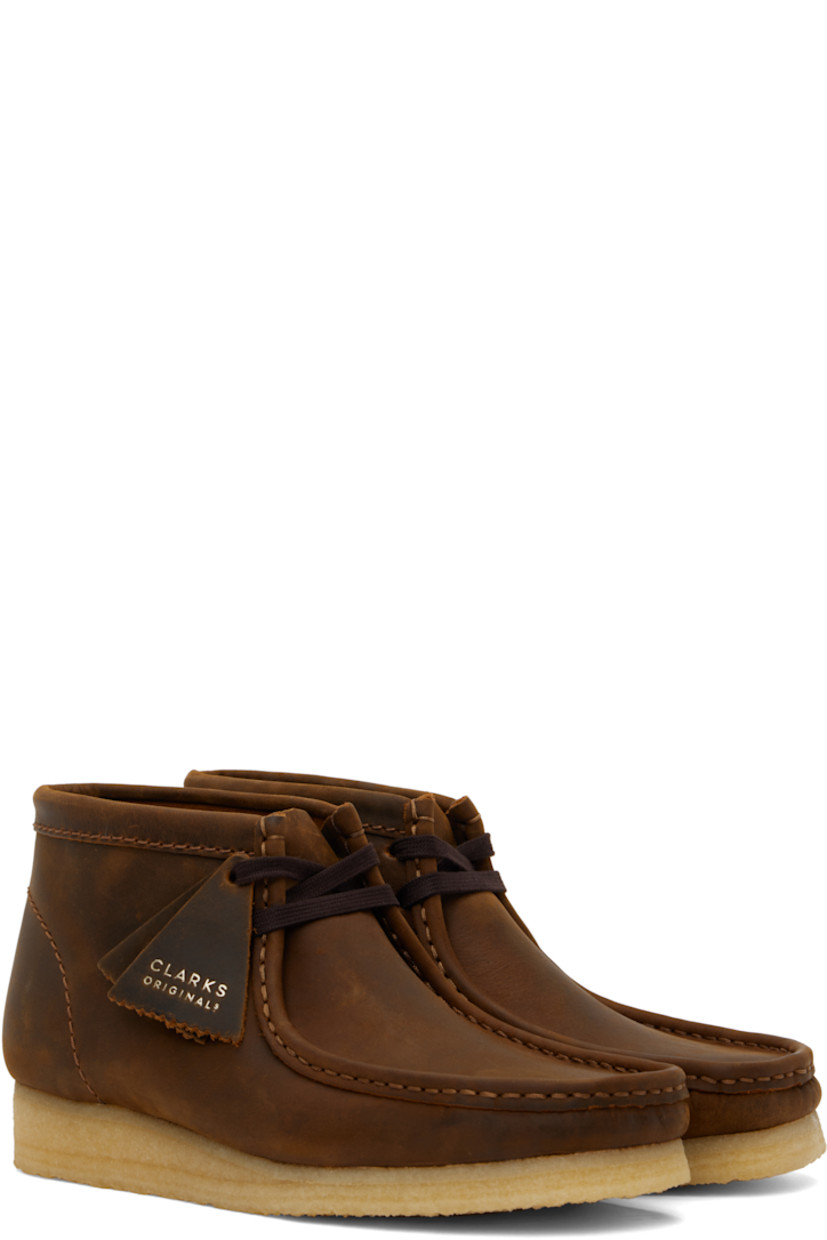 Ankle-high waxed leather desert boots in brown.

· Square moc toe
· Logo tags at lace-up closure
· Suede lining
· FSC-certified crepe rubber sole

Supplier color: Beeswax