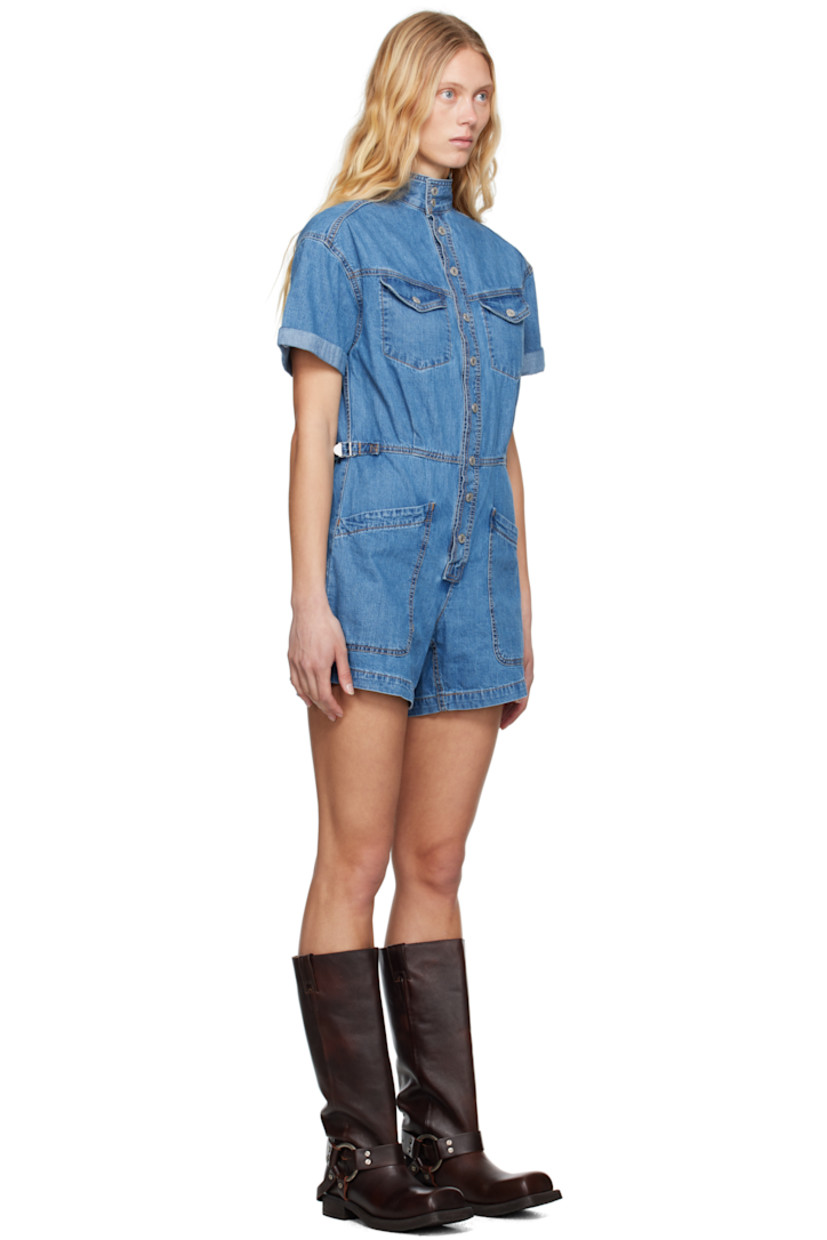 Non-stretch denim romper. Fading throughout. 

· Stand collar
· Press-stud closure
· Flap pockets at chest
· Pleats at front and back 
· Cinch tabs at waistband
· Four-pocket styling
· Rolled cuffs
· Logo patch at back pocket
· Logo-engraved silver-tone hardware
· Contrast stitching in tan

Supplier color: Blue joke