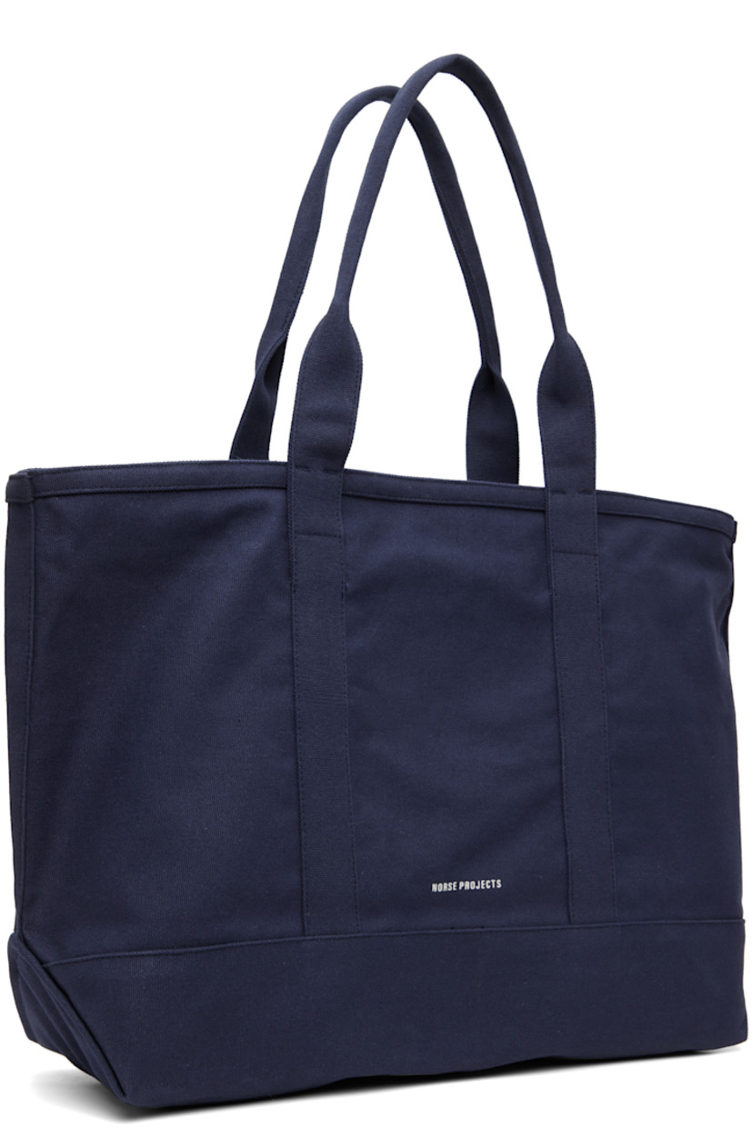 Cotton canvas tote.

· Fixed shoulder straps
· Logo printed at face
· Patch pocket and printed text at back face
· Zip closure
· H14" x W22" x D6.5"

Supplier color: Dark navy