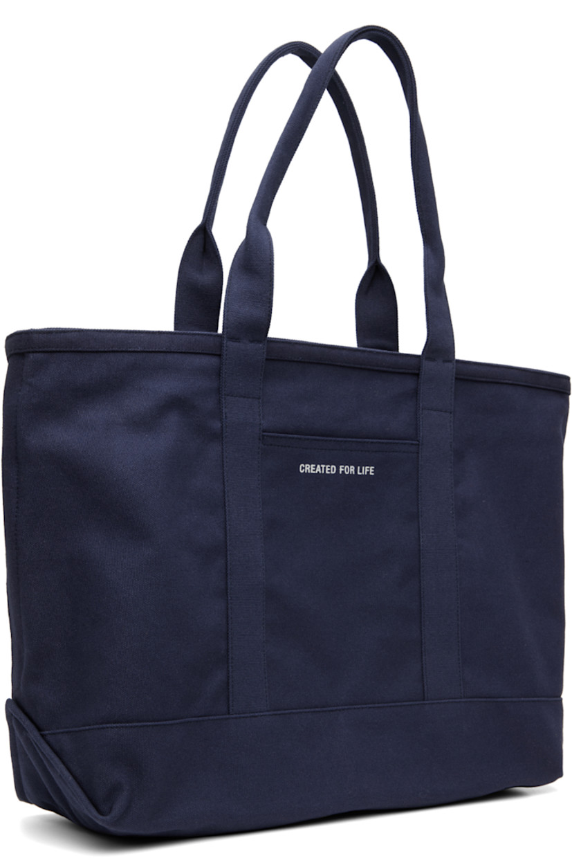 Cotton canvas tote.

· Fixed shoulder straps
· Logo printed at face
· Patch pocket and printed text at back face
· Zip closure
· H14" x W22" x D6.5"

Supplier color: Dark navy