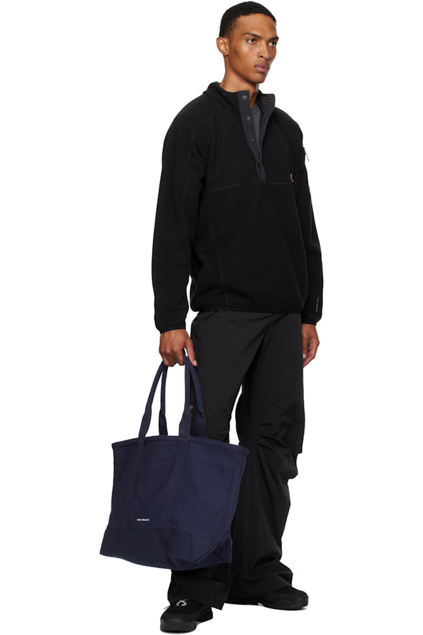 Cotton canvas tote.

· Fixed shoulder straps
· Logo printed at face
· Patch pocket and printed text at back face
· Zip closure
· H14" x W22" x D6.5"

Supplier color: Dark navy