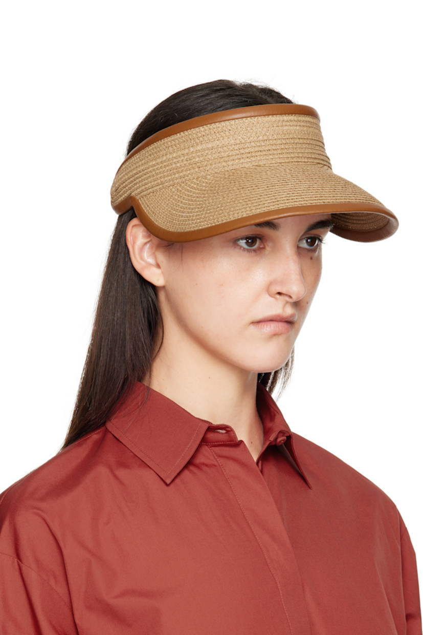 Woven paper visor. 

· Curved brim
· Logo hardware at side
· Adjustable elasticized cinch strap at back face
· Satin browband

Supplier color: Tobacco