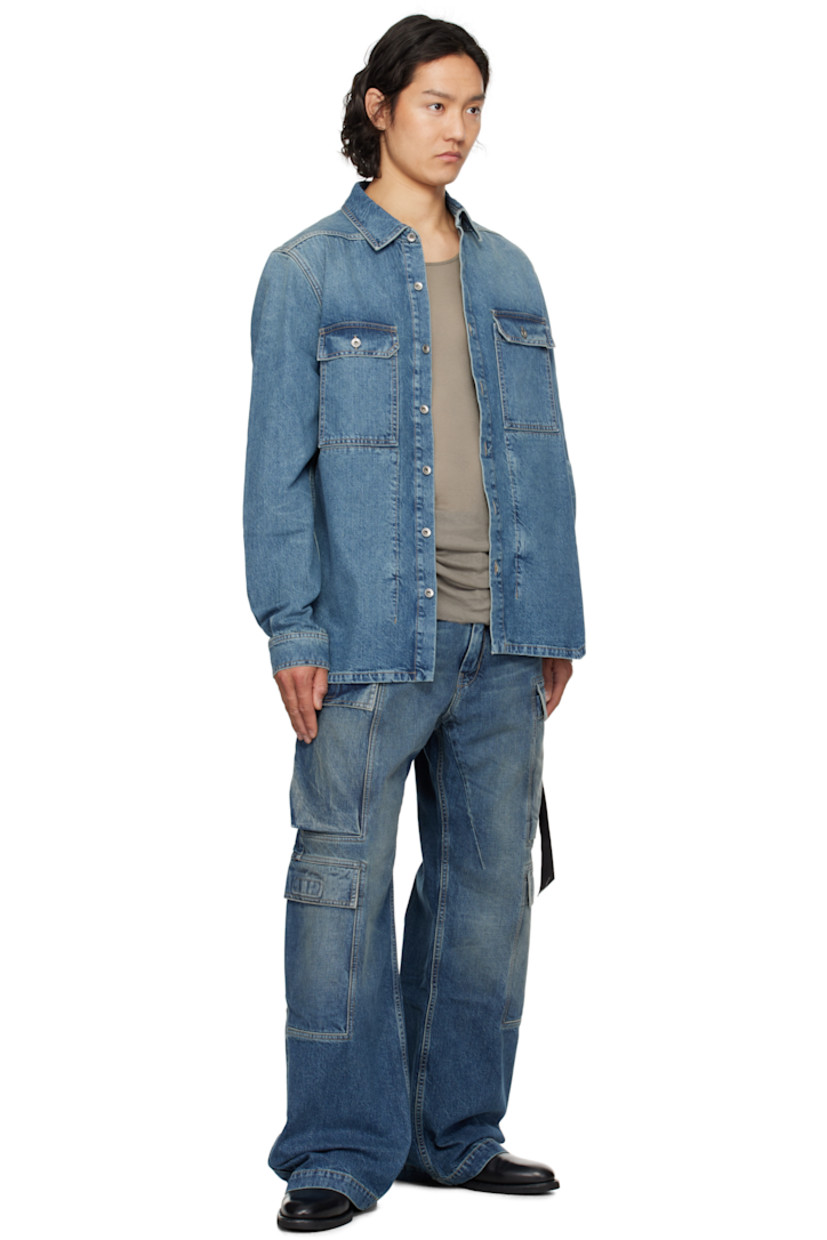 13 oz non-stretch selvedge denim overshirt. Subtle fading throughout.

· ZDHC-certified
· Garment-washed
· Spread collar
· Button closure
· Flap pockets
· Droptail hem
· Beveled side seams
· Saddle shoulders
· Adjustable button fastening at cuffs
· Webbing strap at back yoke
· Zip pockets at interior
· Integrated logo-woven strap
· Silver-tone hardware
· Contrast stitching in tan

Supplier color: Washed indigo