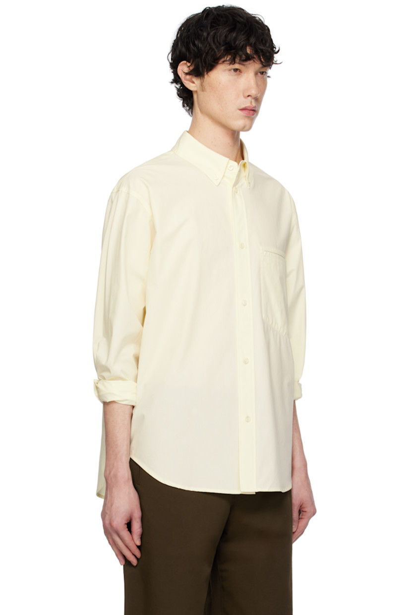 Cotton poplin shirt. 

· Spread collar
· Button closure
· Patch pocket at chest
· Shirttail hem
· Dropped shoulders
· Single-button barrel cuffs
· Box pleat and locker loop at back yoke

Supplier color: Lemon