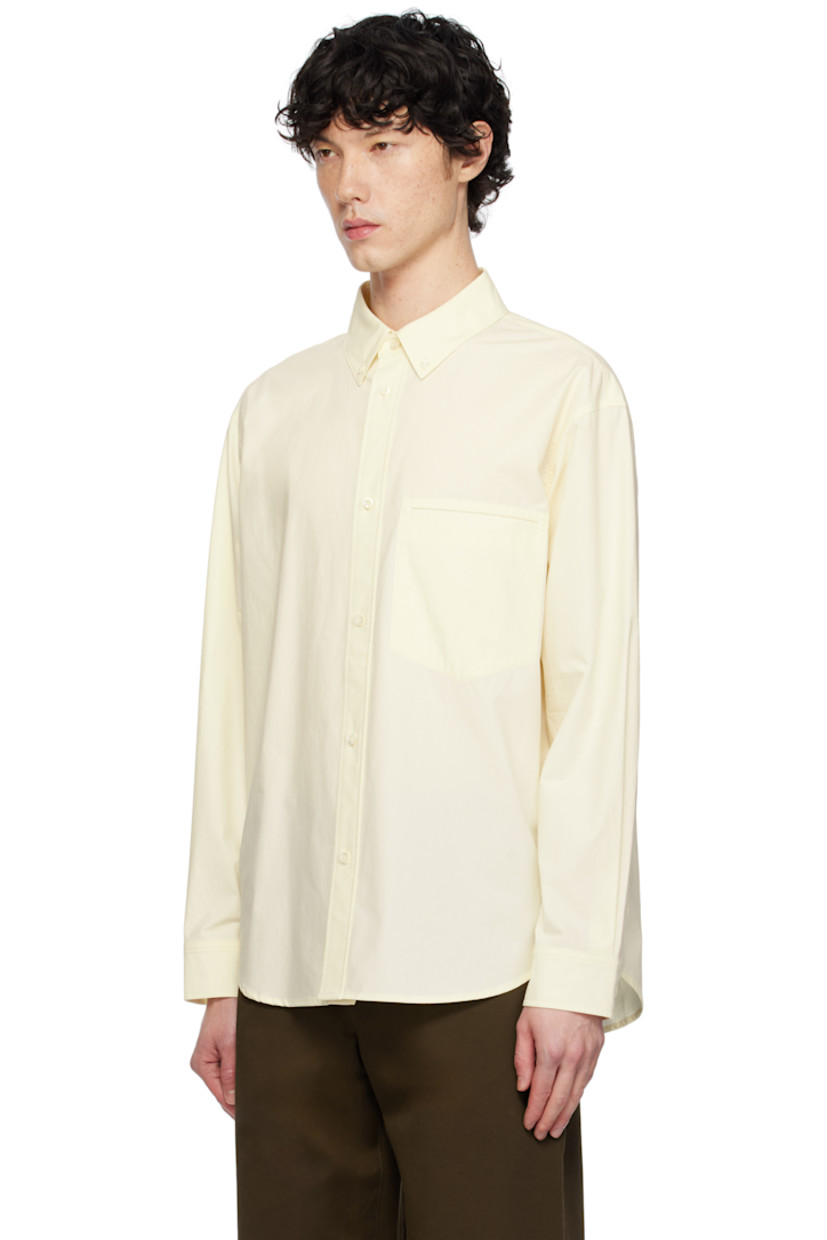 Cotton poplin shirt. 

· Spread collar
· Button closure
· Patch pocket at chest
· Shirttail hem
· Dropped shoulders
· Single-button barrel cuffs
· Box pleat and locker loop at back yoke

Supplier color: Lemon