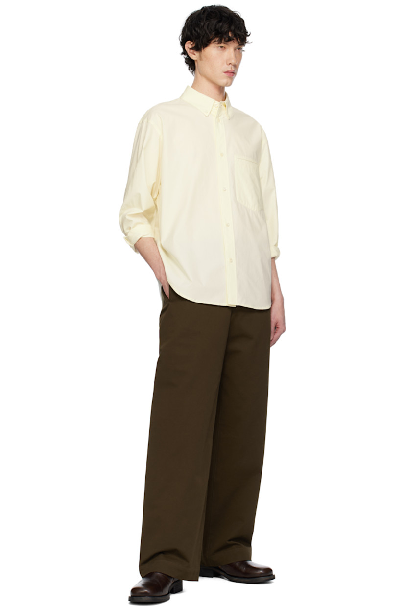Cotton poplin shirt. 

· Spread collar
· Button closure
· Patch pocket at chest
· Shirttail hem
· Dropped shoulders
· Single-button barrel cuffs
· Box pleat and locker loop at back yoke

Supplier color: Lemon