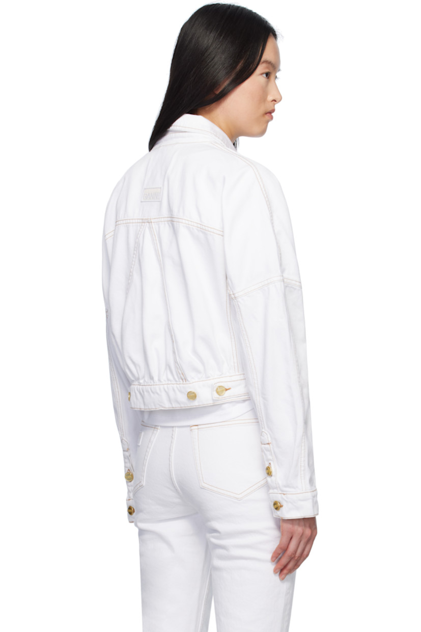 Non-stretch organic cotton denim jacket.

· Spread collar
· Pin-buckle tabs at button closure
· Flap pockets
· Single-button barrel cuffs
· Logo patch at back hem
· Adjustable button tabs at back hem
· Contrast stitching in tan

Supplier color: Bright white