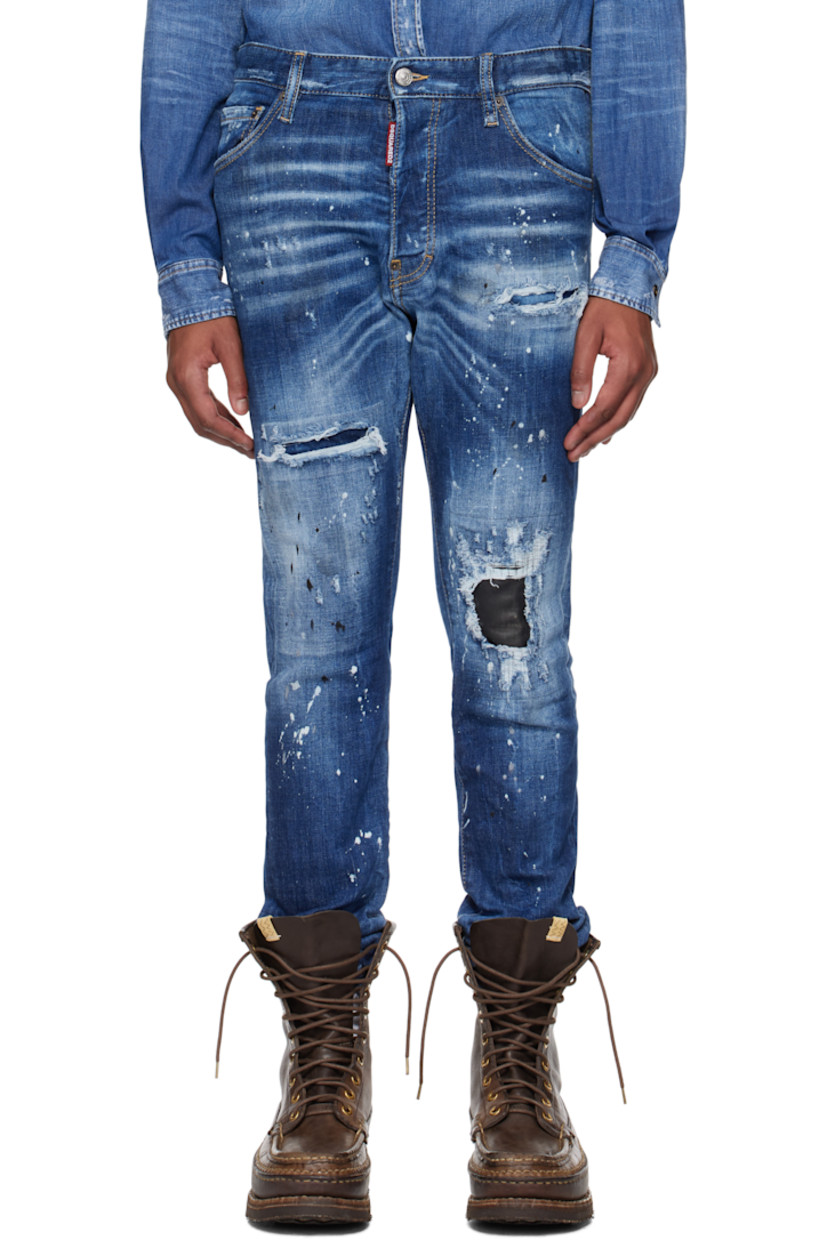 Stretch denim jeans. Fading, distressing, whiskering, and paint splatter throughout. 

· Belt loops
· Five-pocket styling
· Logo flag at button-fly
· Calfskin patch at knee
· Raw edge at cuffs
· Calfskin logo patch at back waistband
· Logo-engraved silver- and copper-tone hardware
· Contrast stitching in tan

Supplier color: Navy