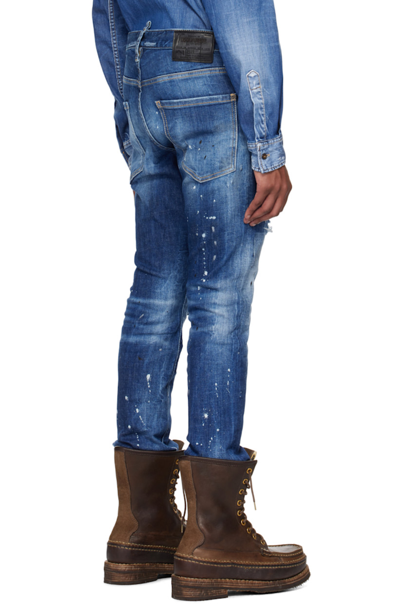 Stretch denim jeans. Fading, distressing, whiskering, and paint splatter throughout. 

· Belt loops
· Five-pocket styling
· Logo flag at button-fly
· Calfskin patch at knee
· Raw edge at cuffs
· Calfskin logo patch at back waistband
· Logo-engraved silver- and copper-tone hardware
· Contrast stitching in tan

Supplier color: Navy
