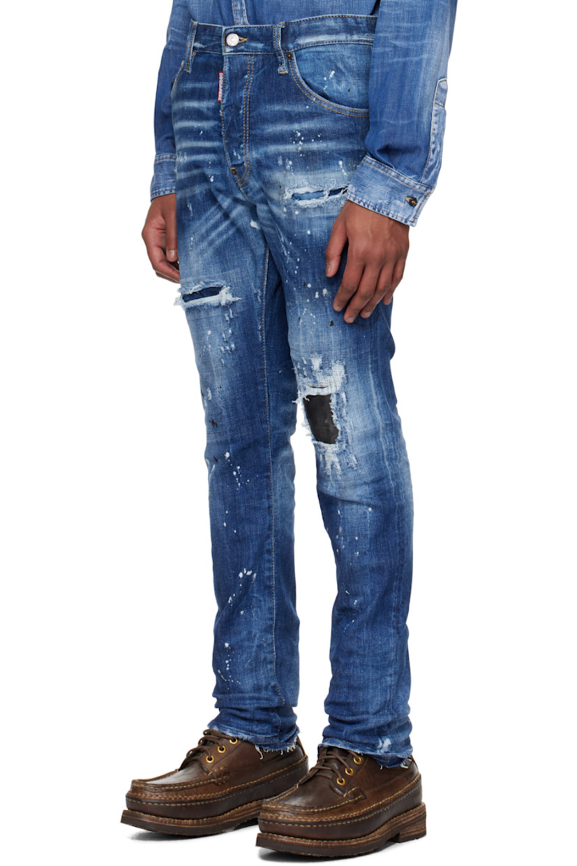 Stretch denim jeans. Fading, distressing, whiskering, and paint splatter throughout. 

· Belt loops
· Five-pocket styling
· Logo flag at button-fly
�· Calfskin patch at knee
· Raw edge at cuffs
· Calfskin logo patch at back waistband
· Logo-engraved silver- and copper-tone hardware
· Contrast stitching in tan

Supplier color: Navy