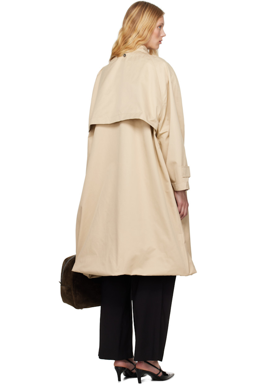 Polyester- and cotton-blend twill trench coat. 

· Bungee-style drawstring at round neck
· Button closure
· Storm flap at chest and back
· Welt pockets
· Bubble hem 
· Raglan sleeves 
· Logo patch at cuff
· Button tab at cuffs
· Unlined 

Detachable viscose- and polyester-blend twill vest. 

· Hook-eye fastening at spread collar 
· Button closure
· Welt pocket at interior 
· Full satin lining 

Supplier color: Champagne beige