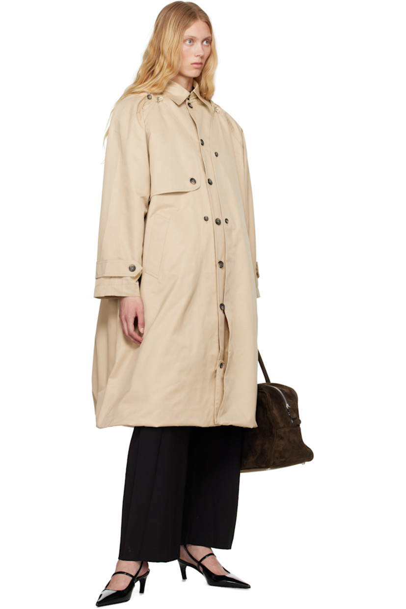 Polyester- and cotton-blend twill trench coat. 

· Bungee-style drawstring at round neck
· Button closure
· Storm flap at chest and back
· Welt pockets
· Bubble hem 
· Raglan sleeves 
· Logo patch at cuff
· Button tab at cuffs
· Unlined 

Detachable viscose- and polyester-blend twill vest. 

· Hook-eye fastening at spread collar 
· Button closure
· Welt pocket at interior 
· Full satin lining 

Supplier color: Champagne beige