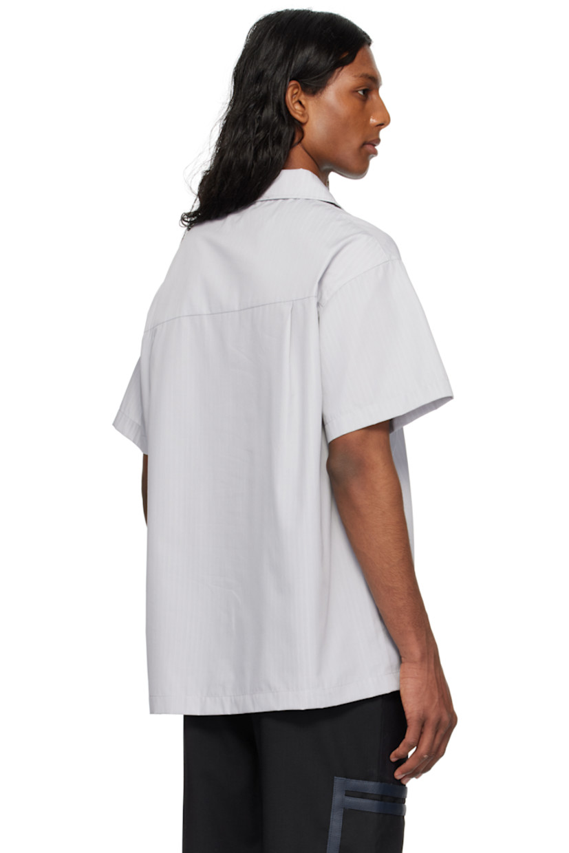 Cotton poplin shirt. Stripes throughout. 

· Press-stud fastening and piping at spread collar
· Flap pocket at chest
· Twin pleats at yoke

Supplier color: Grey