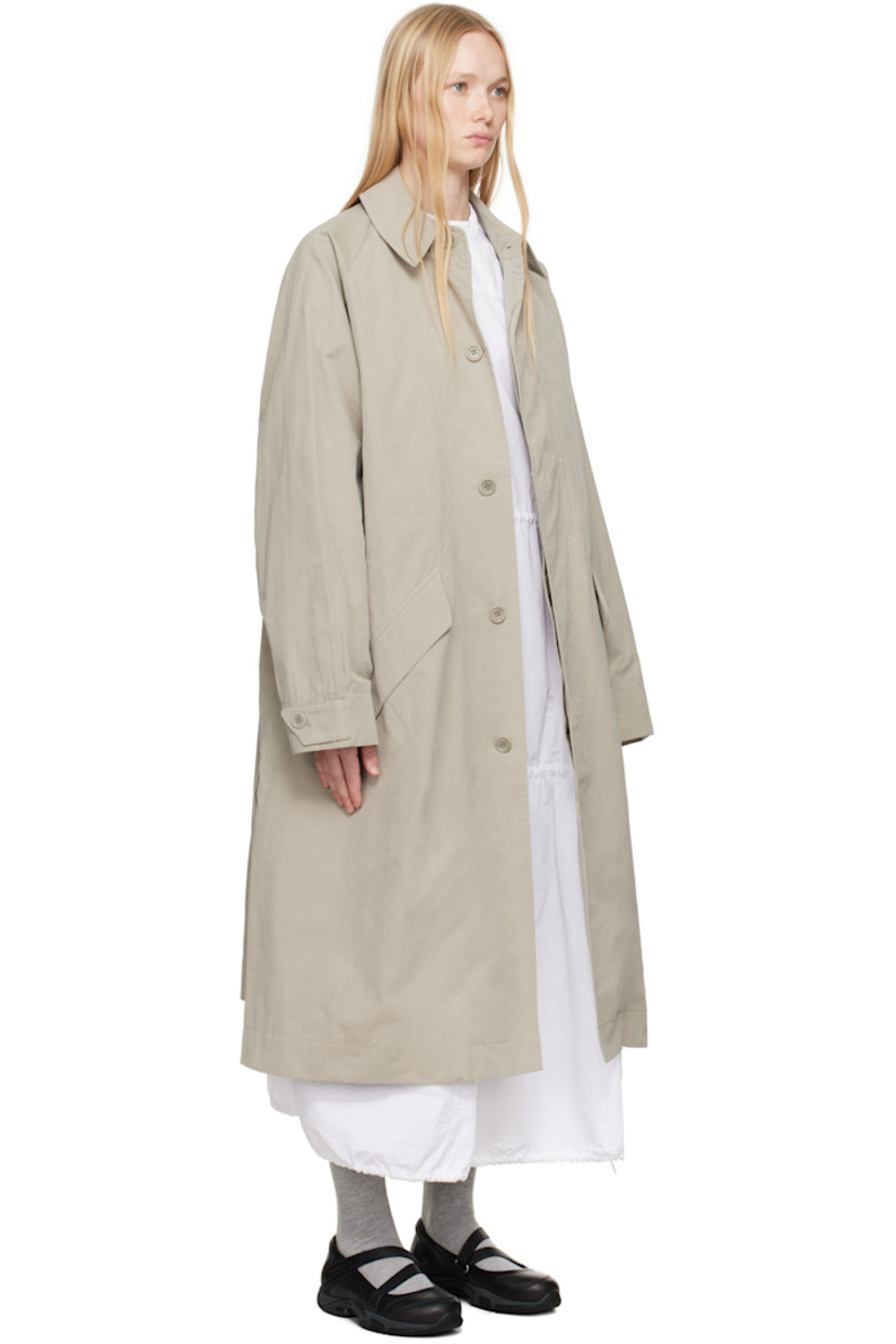 Waxed cotton-blend canvas trench coat. 

· Spread collar
· Concealed button closure
· Zip pocket at chest
· Flap pockets at front 
· Raglan sleeves
· Adjustable button tab at cuffs
· Twin vents at back hem 
· Patch pocket and button tab at interior 
· Full satin lining

Supplier color: Stone