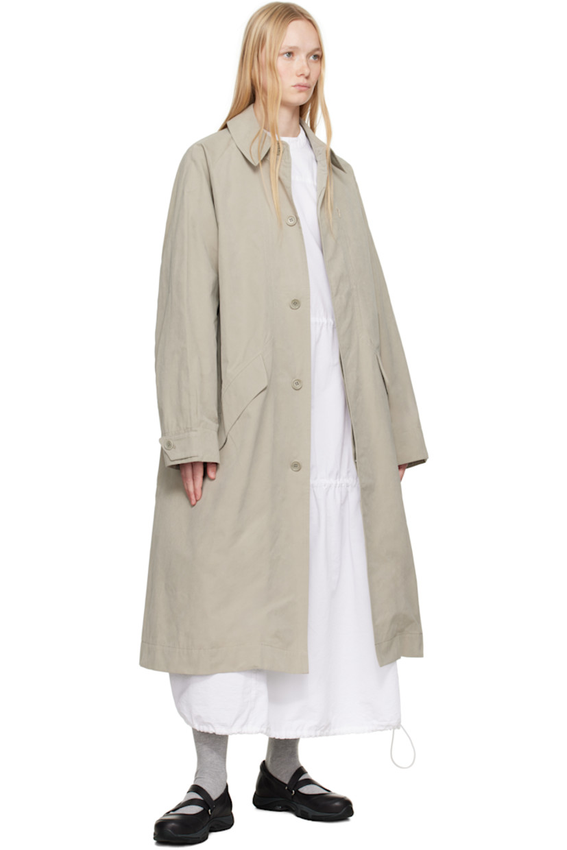 Waxed cotton-blend canvas trench coat. 

· Spread collar
· Concealed button closure
· Zip pocket at chest
· Flap pockets at front 
· Raglan sleeves
· Adjustable button tab at cuffs
· Twin vents at back hem 
· Patch pocket and button tab at interior 
· Full satin lining

Supplier color: Stone