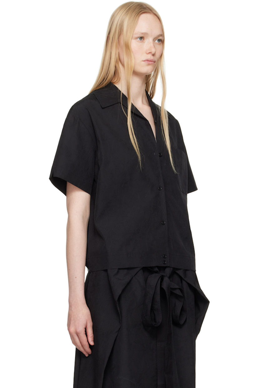 Crinkled polyester taffeta shirt. 

· Open spread collar
· Button closure
· Patch pocket
· Inverted box pleat at back 
· Adjustable button tabs at back hem 
· Corozo hardware 

Supplier color: Black