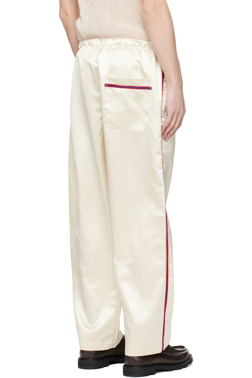 Polyester satin pyjama pants.

· Drawstring at elasticized waistband
· Three-pocket styling
· Exposed button fly
· Striped trim at outseams

This item is part of a limited run of 63.

Supplier color: Cream
