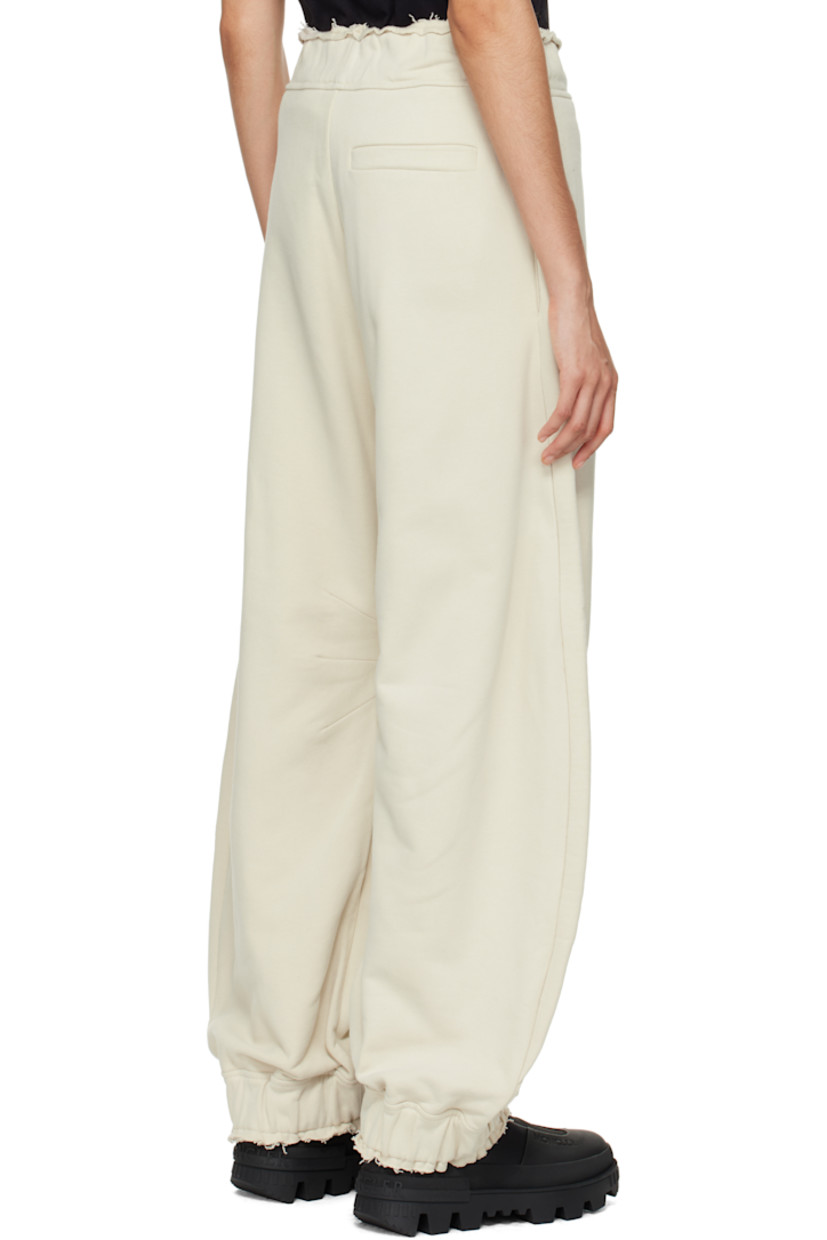 French terry sweatpants.

· Concealed drawstring at elasticized waistband
· Raw edge at waistband and cuffs
· Three-pocket styling
· Embroidered logo patch with O-ring at front
· Darts at inseams
· Elasticized cuffs

Part of the Moncler Genius x Willow Smith collaboration.

Supplier color: Beige