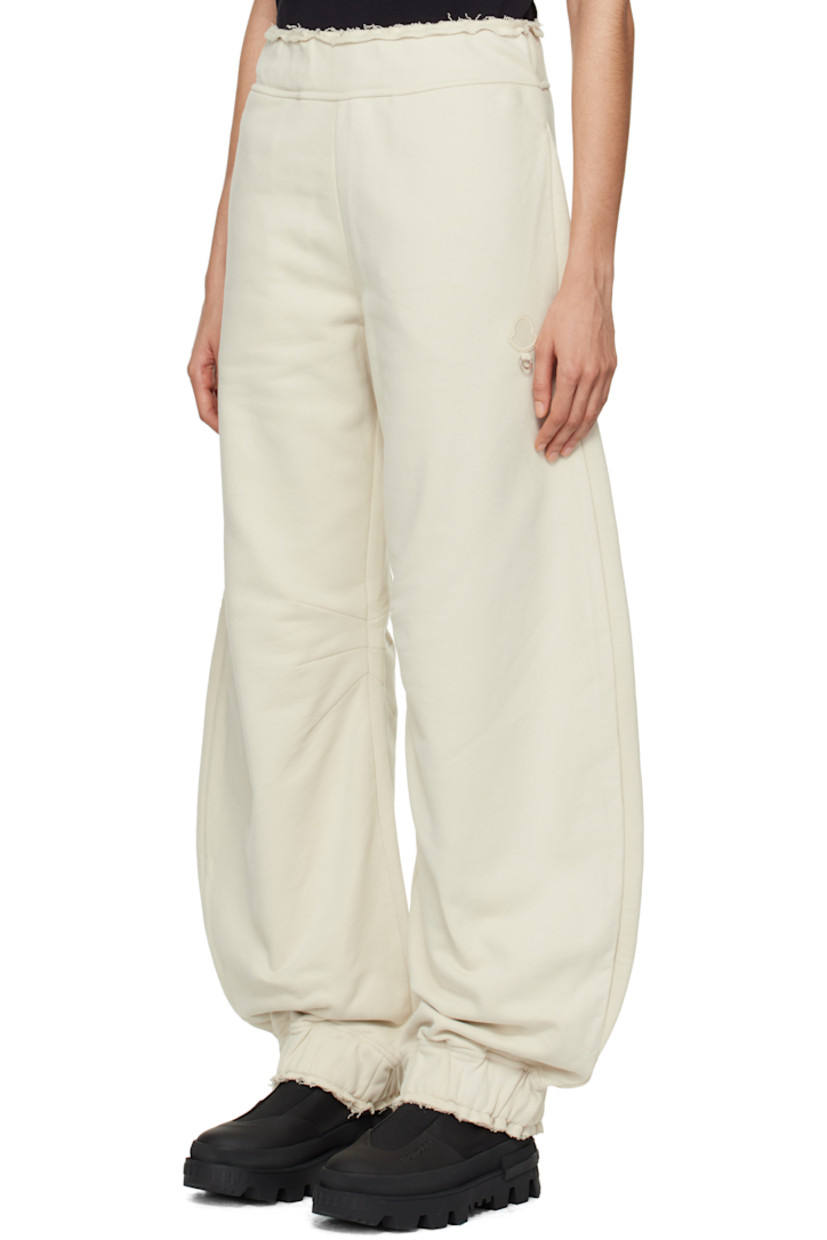 French terry sweatpants.

· Concealed drawstring at elasticized waistband
· Raw edge at waistband and cuffs
· Three-pocket styling
· Embroidered logo patch with O-ring at front
· Darts at inseams
· Elasticized cuffs

Part of the Moncler Genius x Willow Smith collaboration.

Supplier color: Beige