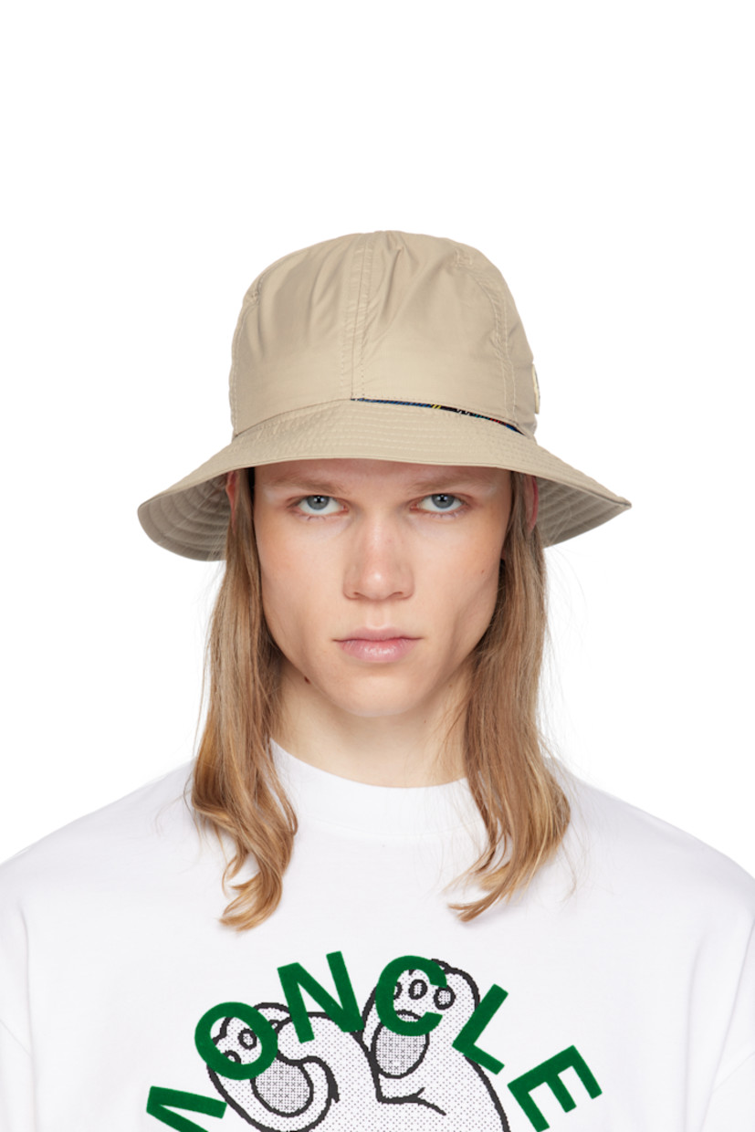 Reversible GORE-TEX INFINIUM™ nylon ripstop bucket hat in beige. Water-resistant.

Reverse in checkered blue, red, yellow, and green taffeta.

· Logo patch and printed text at face
· Quilted brim
· Quilted canvas browband

Part of the Moncler Genius x FRGMT collaboration.

Supplier color: Beige