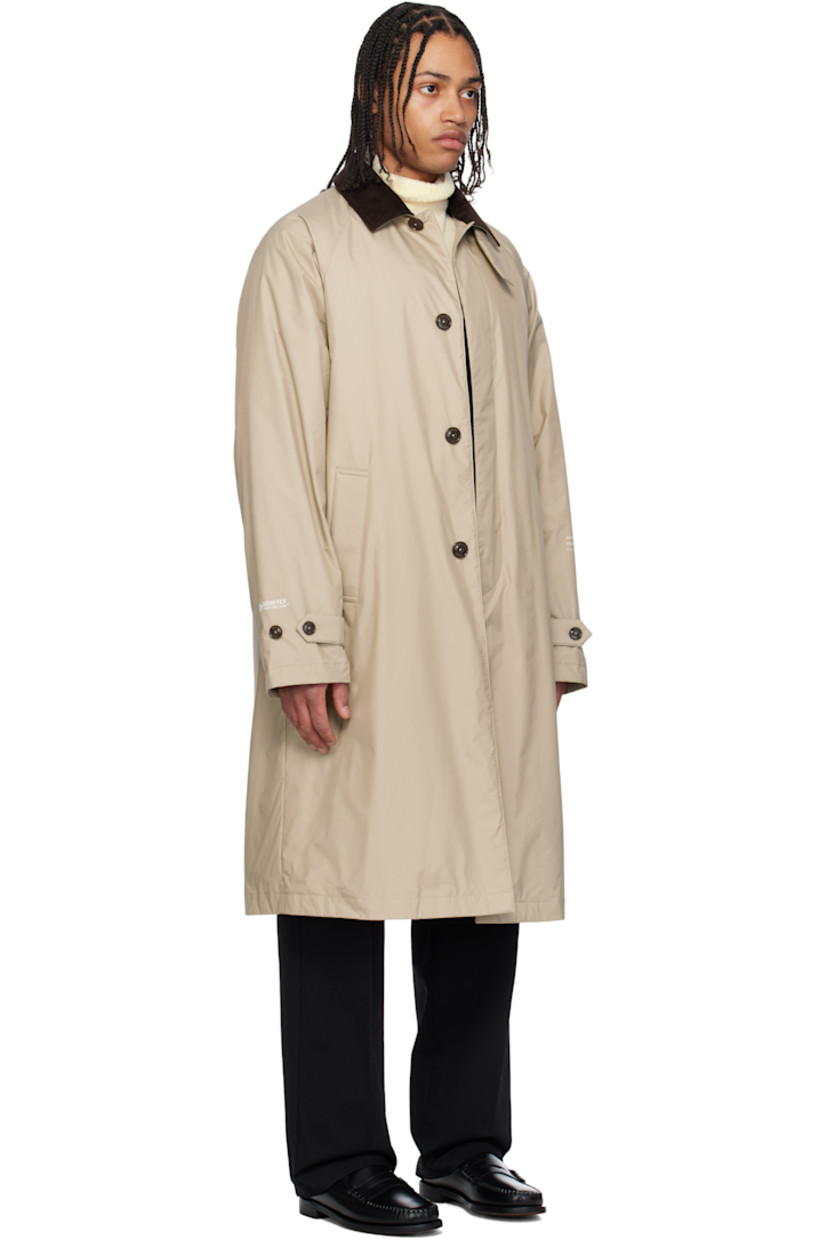 Down-filled 2L GORE-TEX INFINIUM™ nylon ripstop coat. 

· DIST-certified down
· Button tab at cotton corduroy spread collar
· Concealed button closure
· Welt pockets
· Raglan sleeves
· Felted logo patch and printed logo at sleeve
· Text printed at cuffs
· Adjustable buttoned tab at cuffs
· Central vent at back hem 
· Full nylon laqué lining

Part of the Moncler Genius x FRGMT by Hiroshi Fujiwara collaboration.

Supplier color: Sand beige

Fill: 90% goose down, 10% feather.