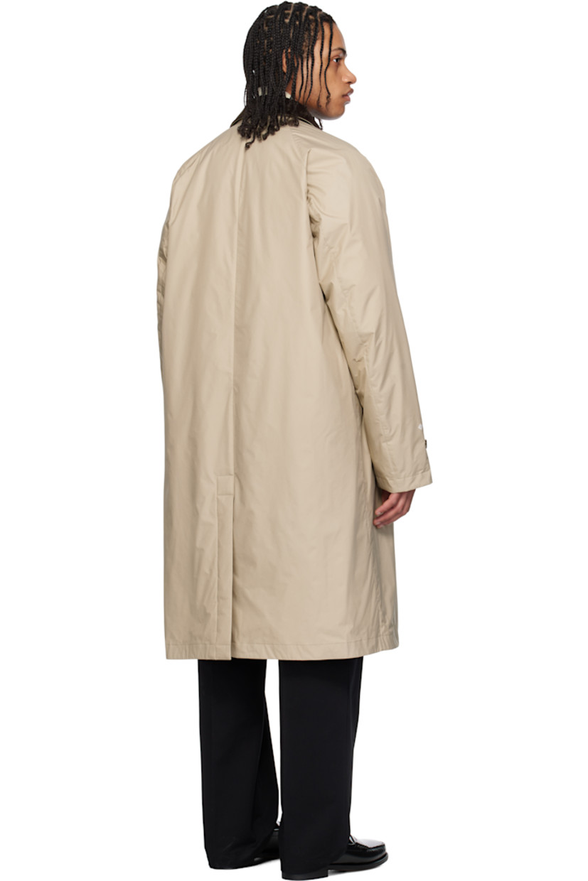 Down-filled 2L GORE-TEX INFINIUM™ nylon ripstop coat. 

· DIST-certified down
· Button tab at cotton corduroy spread collar
· Concealed button closure
· Welt pockets
· Raglan sleeves
· Felted logo patch and printed logo at sleeve
· Text printed at cuffs
· Adjustable buttoned tab at cuffs
· Central vent at back hem 
· Full nylon laqué lining

Part of the Moncler Genius x FRGMT by Hiroshi Fujiwara collaboration.

Supplier color: Sand beige

Fill: 90% goose down, 10% feather.
