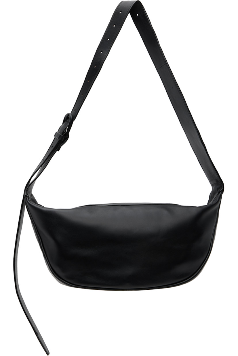 Vegetable-tanned buffed leather shoulder bag.

· LWG-certified leather
· Adjustable pin-buckle shoulder strap
· Zip closure
· Goatskin suede lining
· H7" x W13" x D3.5"

Supplier color: Black