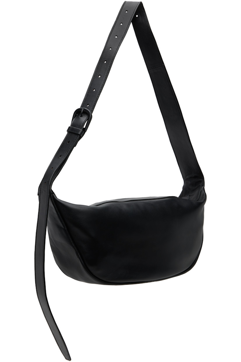 Vegetable-tanned buffed leather shoulder bag.

· LWG-certified leather
· Adjustable pin-buckle shoulder strap
· Zip closure
· Goatskin suede lining
· H7" x W13" x D3.5"

Supplier color: Black