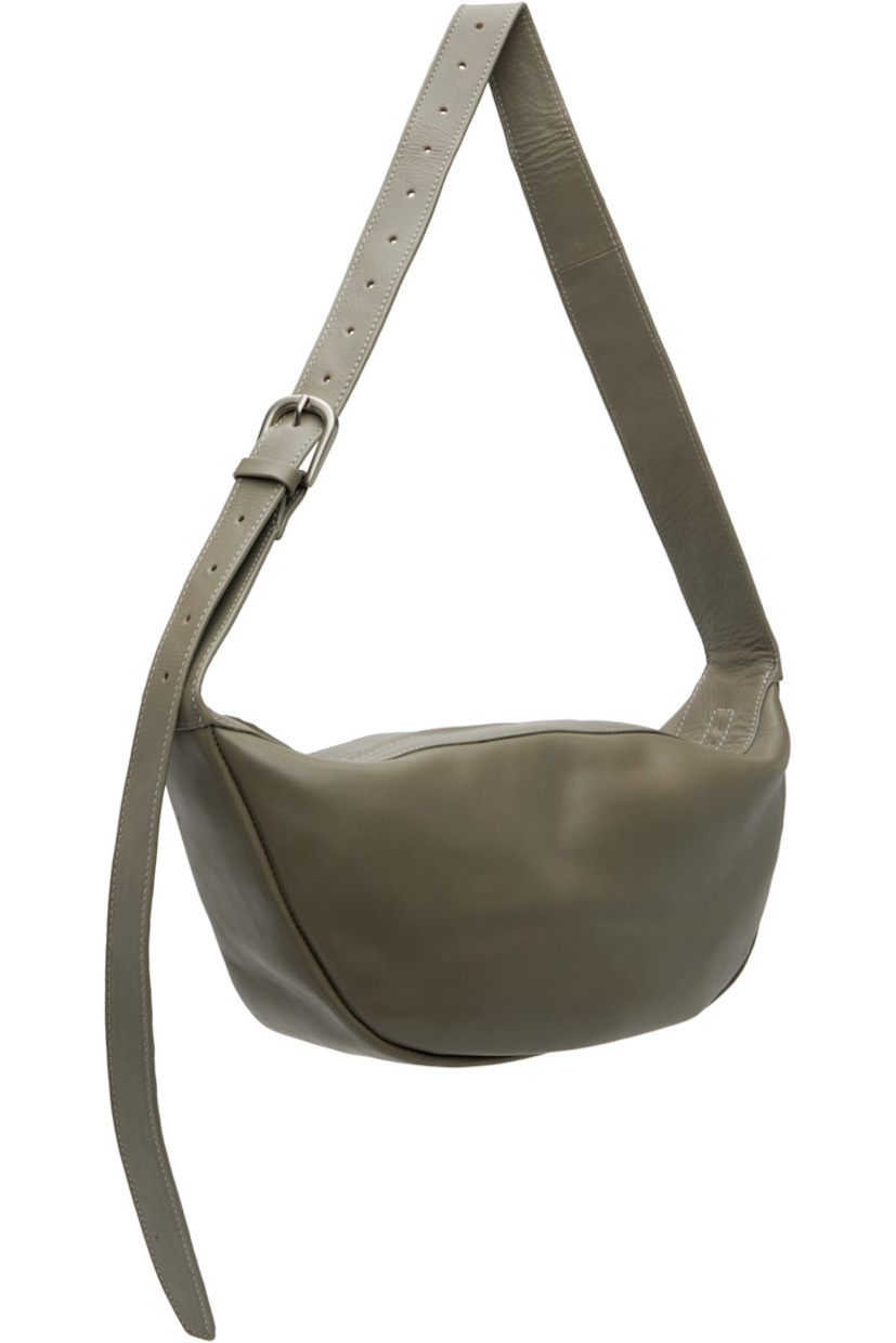 Vegetable-tanned buffed leather shoulder bag.

· LWG-certified leather
· Adjustable pin-buckle shoulder strap
· Zip closure
· Goatskin suede lining
· H7" x W13" x D3.5"

Supplier color: Slate