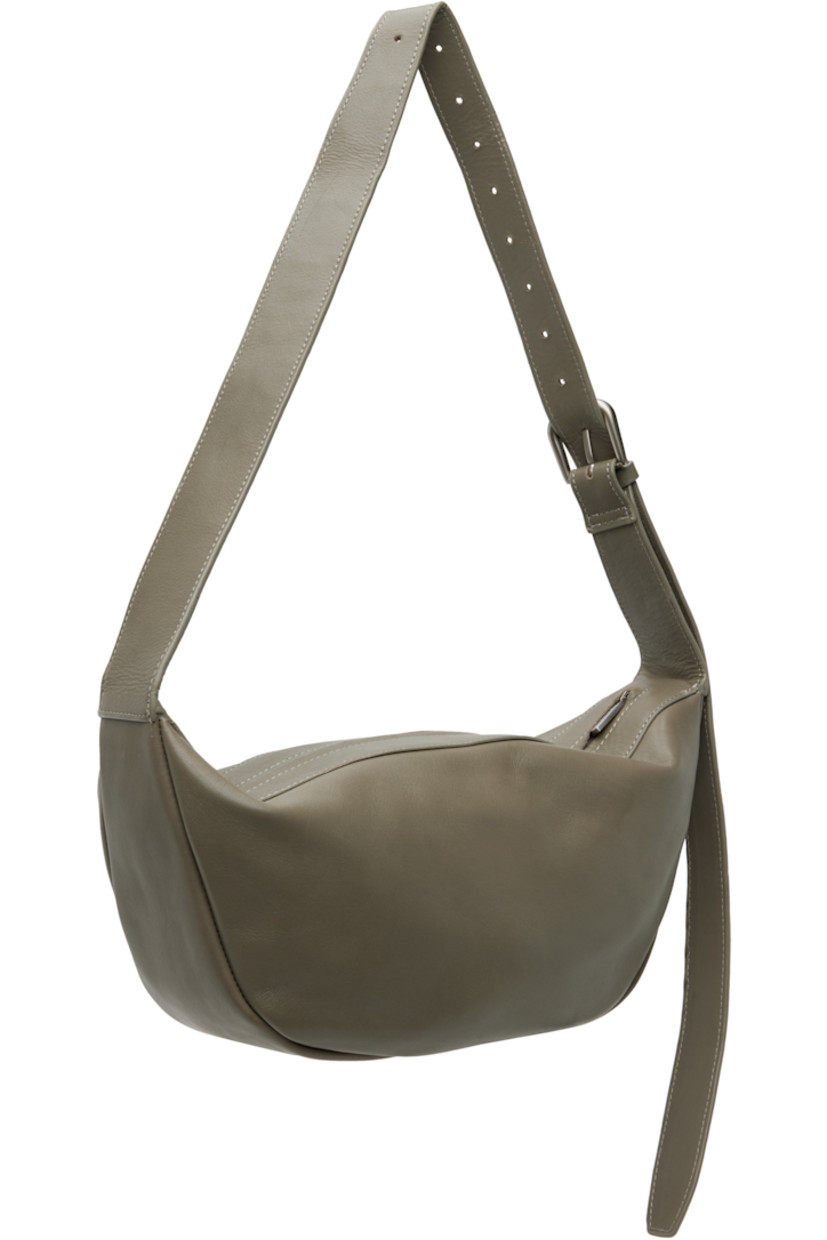Vegetable-tanned buffed leather shoulder bag.

· LWG-certified leather
· Adjustable pin-buckle shoulder strap
· Zip closure
· Goatskin suede lining
· H7" x W13" x D3.5"

Supplier color: Slate