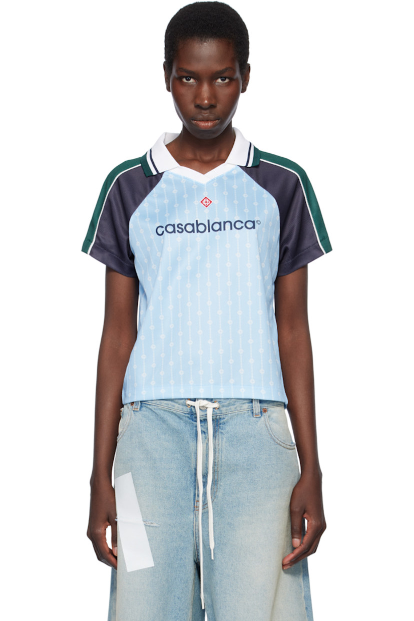 Polyester mesh T-shirt. Logo graphic pinstripes printed throughout.

· Striped rib-knit spread collar at V-neck
· Embroidered logo patch at chest
· Logo printed at front 
· Piping at raglan sleeves

Supplier color: Blue