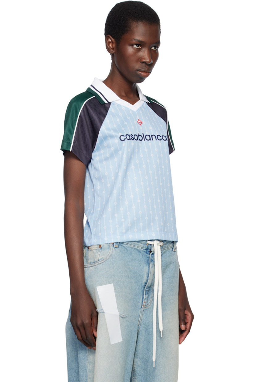 Polyester mesh T-shirt. Logo graphic pinstripes printed throughout.

· Striped rib-knit spread collar at V-neck
· Embroidered logo patch at chest
· Logo printed at front 
· Piping at raglan sleeves

Supplier color: Blue