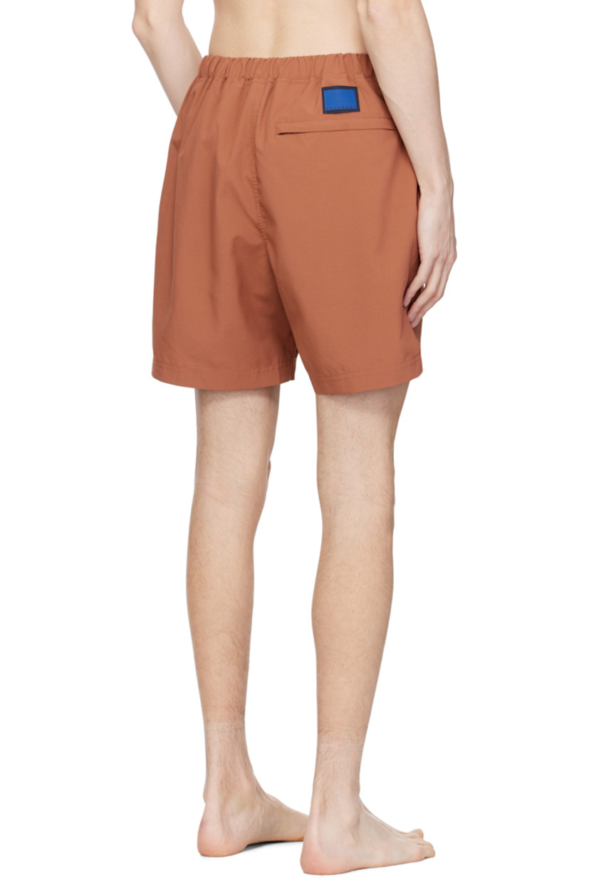 Taffeta swim shorts. 

· Concealed drawstring at elasticized waistband
· Three-pocket styling
· Logo patch at back waistband
· Partial mesh lining 

Supplier color: Brick