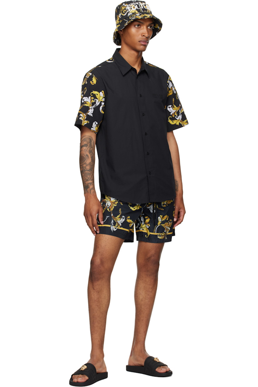 Cotton poplin shirt.

· Spread collar
· Button closure
· Logo bonded at chest
· Shirttail hem
· Barocco pattern printed at sleeves and back yoke

Supplier color: Black/Gold