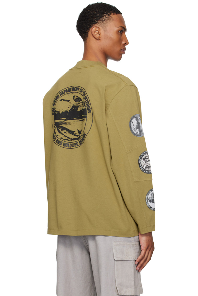 Heavyweight cotton jersey T-shirt.

· Rib-knit crewneck
· Logo printed at chest
· Paneled sleeves
· Printed graphics at sleeve
· Raised text and printed graphics at back

Supplier color: Olive drab