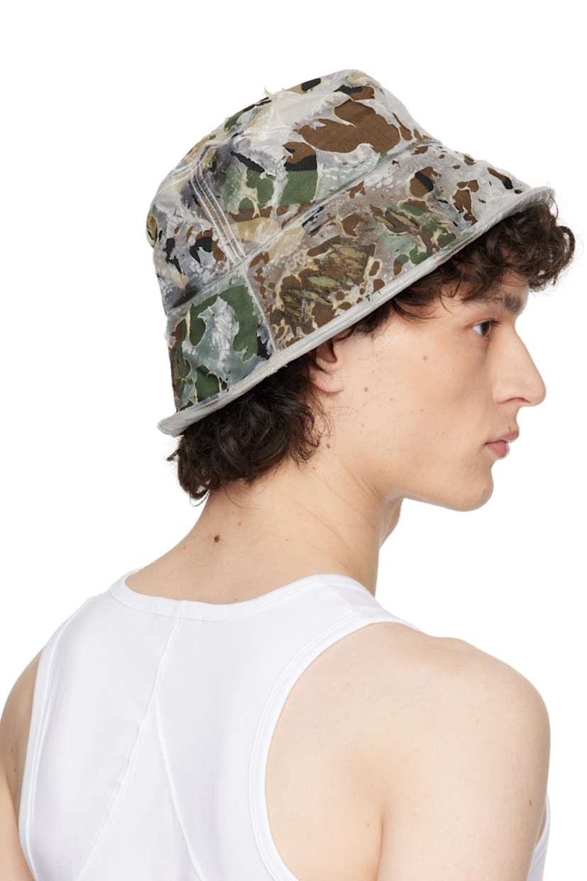 Coated ripstop hat in tones of green. Camouflage pattern and distressing throughout. 

Supplier color: Multi burn