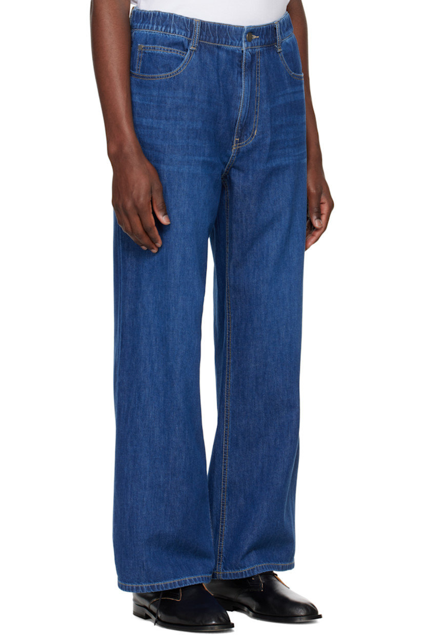 Bootcut non-stretch denim jeans. Fading and whiskering throughout. 

· Belt loops at elasticized waistband 
· Five-pocket styling 
· Zip fly 
· Suede logo patch at back waistband 
· Logo-engraved silver-tone hardware
· Contrast stitching in tan

Supplier color: Blue