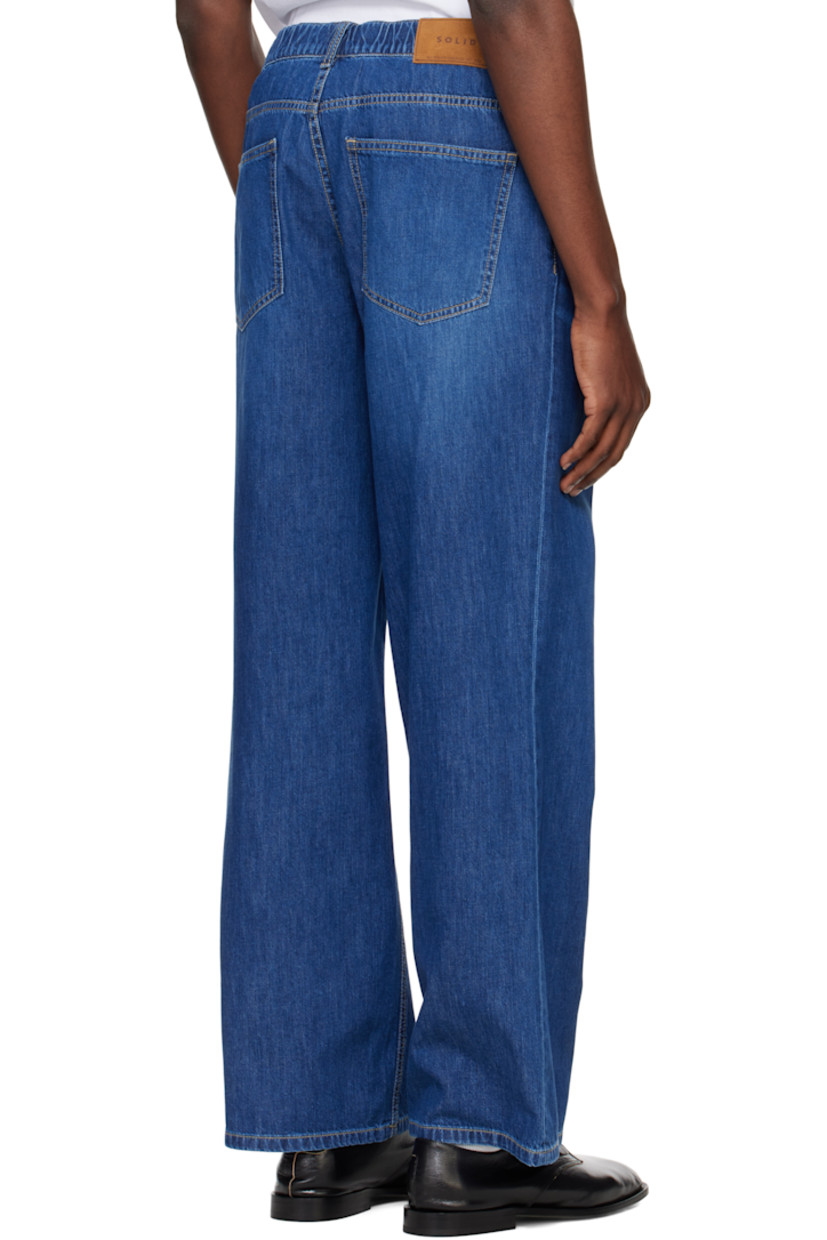 Bootcut non-stretch denim jeans. Fading and whiskering throughout. 

· Belt loops at elasticized waistband 
· Five-pocket styling 
· Zip fly 
· Suede logo patch at back waistband 
· Logo-engraved silver-tone hardware
· Contrast stitching in tan

Supplier color: Blue