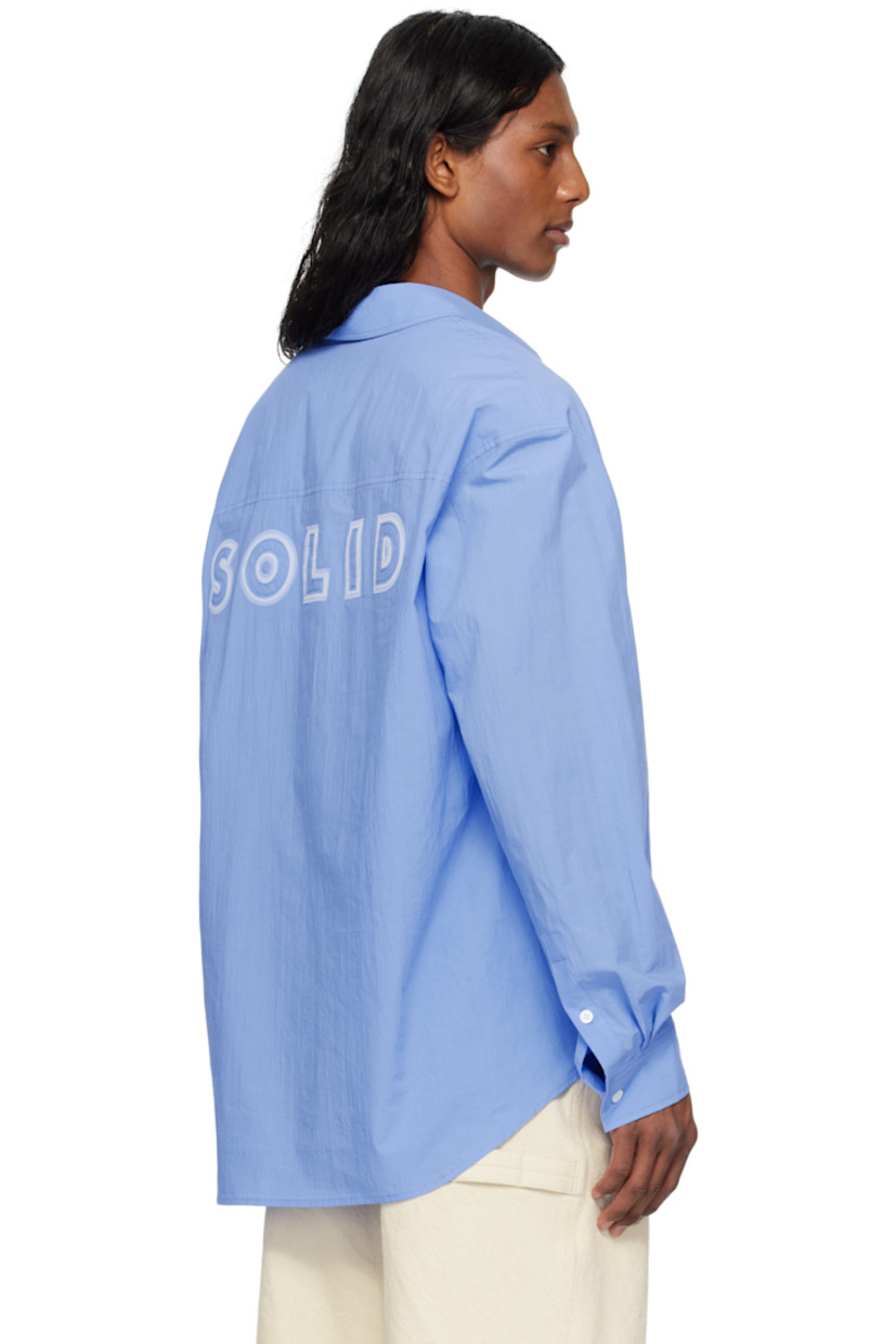 Cotton poplin shirt.

· Spread collar
· Button closure
· Patch pocket
· Shirttail hem
· Buttoned barrel cuffs
· Logo appliqué at back

Supplier color: Blue