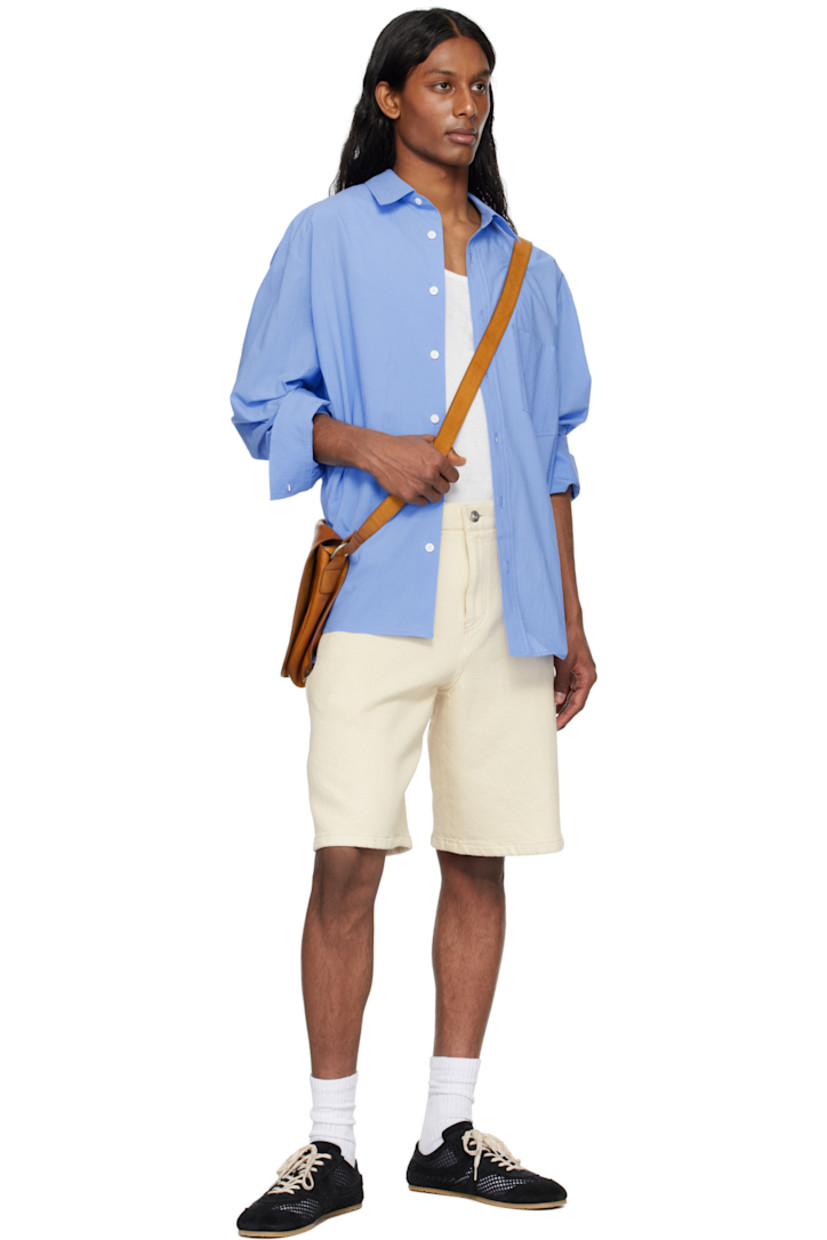 Cotton poplin shirt.

· Spread collar
· Button closure
· Patch pocket
· Shirttail hem
· Buttoned barrel cuffs
· Logo appliqué at back

Supplier color: Blue