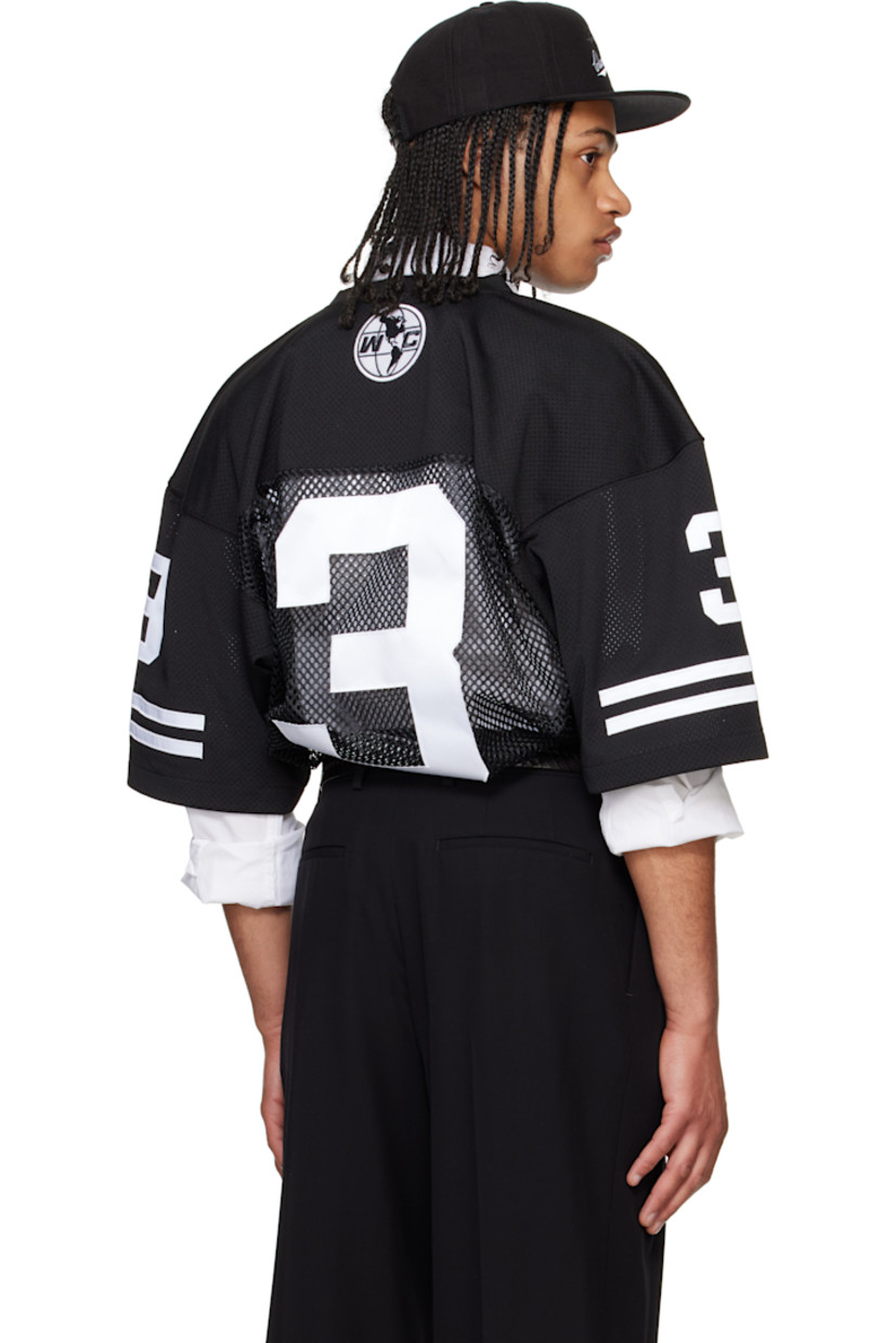 Polyester mesh T-shirt.

· Paneled construction
· Rib-knit V-neck
· Text appliqués at front, sleeves, and back
· Dropped shoulders
· Stripe appliqués at sleeves
· Embroidered logo patch at back collar

Supplier color: Black