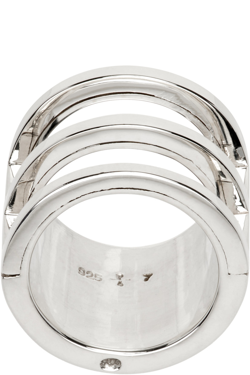 Ring in polished sterling silver. 

· Cutouts at face
· Hallmarking at inner band

Supplier color: Polished silver