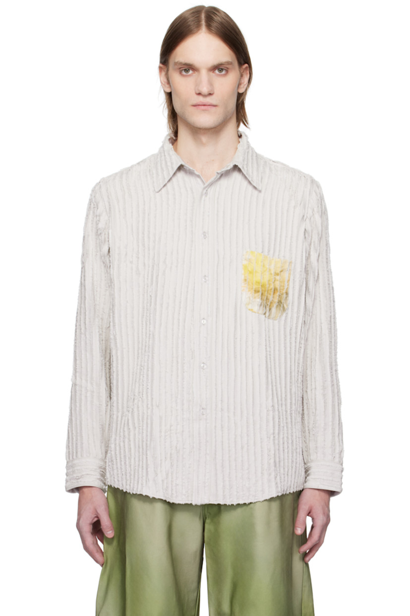 Plain-woven rayon shirt. Pinched seams with frayed edges throughout.

· Spread collar
· Button closure
· Graphic printed at patch pocket and back 
· Shirttail hem
· Buttoned barrel cuffs

Supplier color: Stone flower drip
