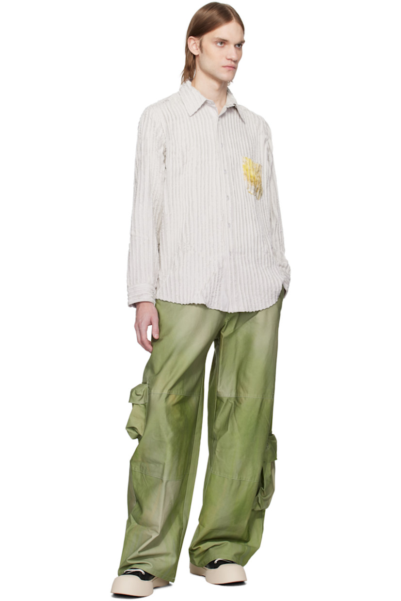 Plain-woven rayon shirt. Pinched seams with frayed edges throughout.

· Spread collar
· Button closure
· Graphic printed at patch pocket and back 
· Shirttail hem
· Buttoned barrel cuffs

Supplier color: Stone flower drip