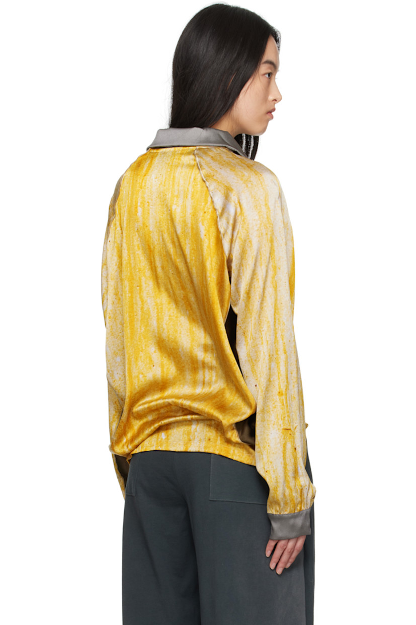 Stretch silk satin polo. Graphic pattern printed throughout.

· Spread collar
· Logos embroidered at chest
· Logo and text bonded at front
· Piping at raglan sleeves 

Supplier color: Print