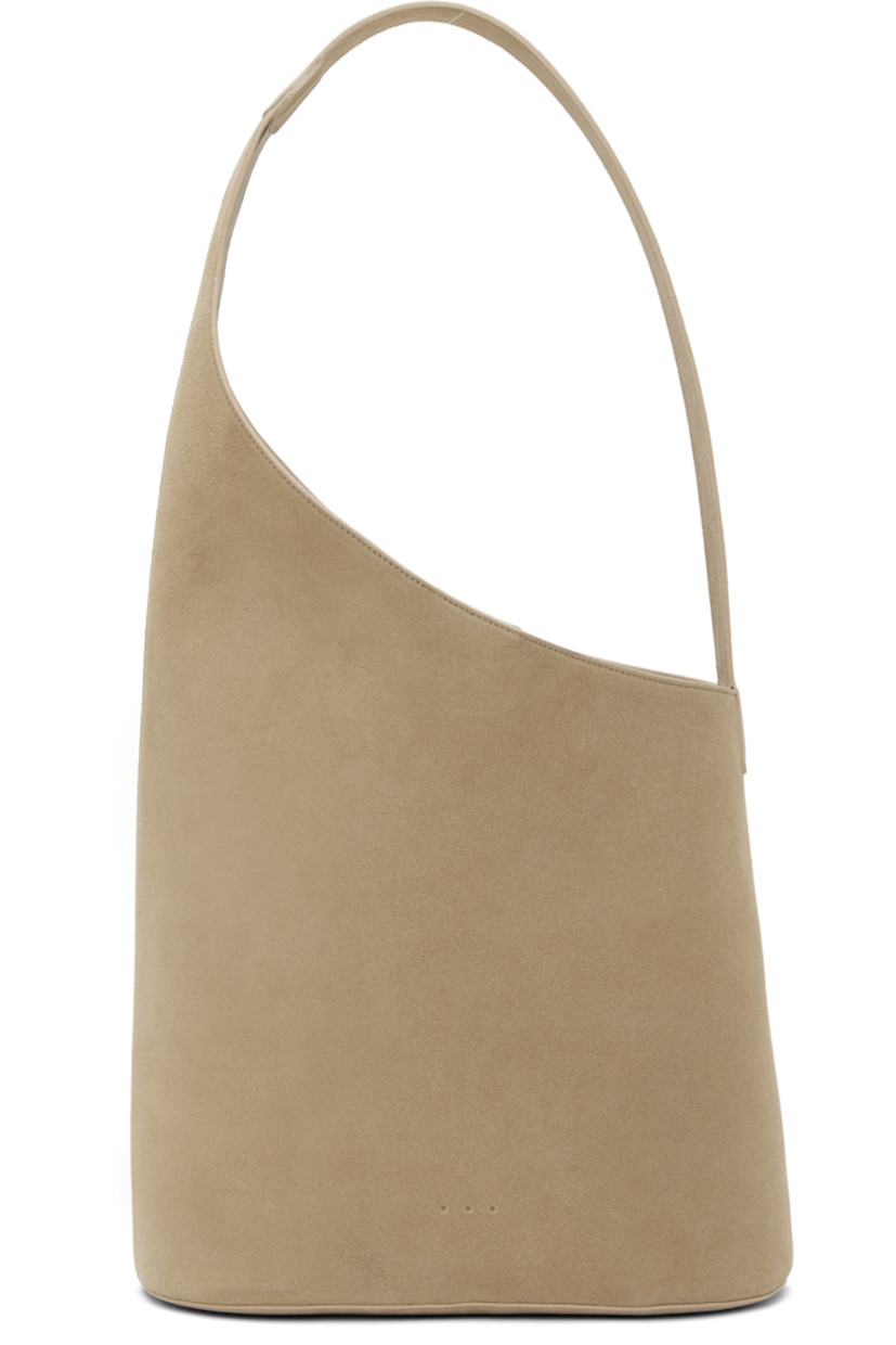 Calfskin suede tote in beige.

· Fixed shoulder strap
· Logo embossed at face
· Magnetic closure
· Patch pocket at interior
· Buffed faux-leather lining
· H10.5" x W11" x D5"
· Total height: H20.5"

Supplier color: Suede sand