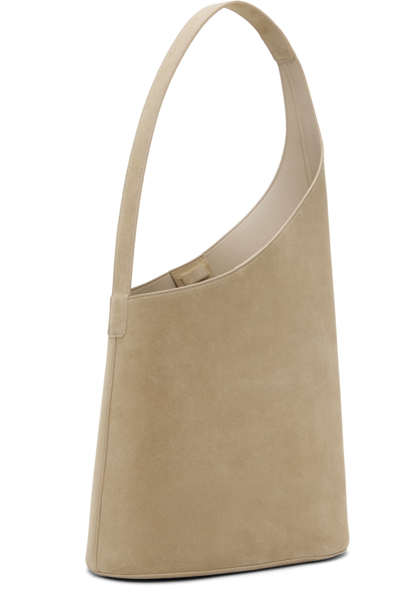 Calfskin suede tote in beige.

· Fixed shoulder strap
· Logo embossed at face
· Magnetic closure
· Patch pocket at interior
· Buffed faux-leather lining
· H10.5" x W11" x D5"
· Total height: H20.5"

Supplier color: Suede sand