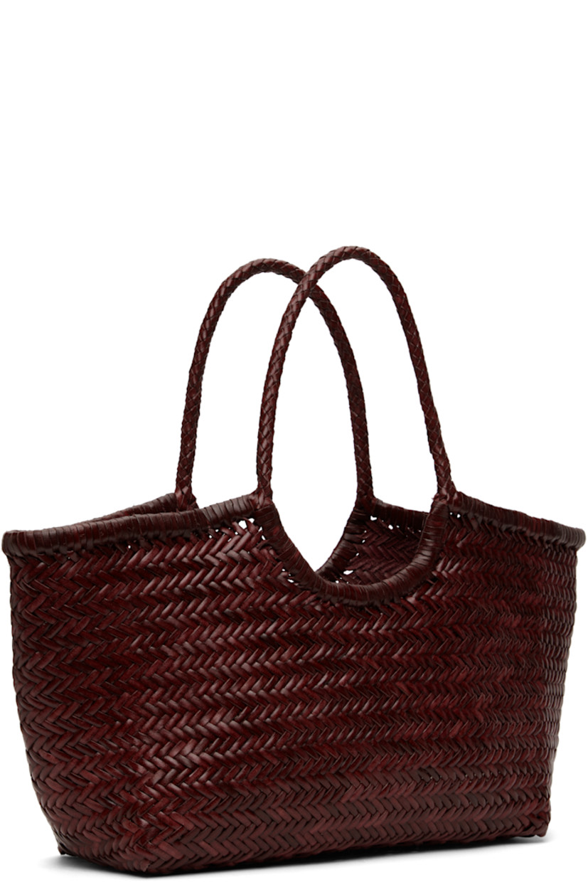 Hand-woven buffalo calfskin top handle bag in burgundy.

· Twin carry handles
· Open throat
· Hand-sewn logo disc at interior
· Unlined
· H9.5" x W19" x D6"
· Total height: H17"

Supplier color: Bordo